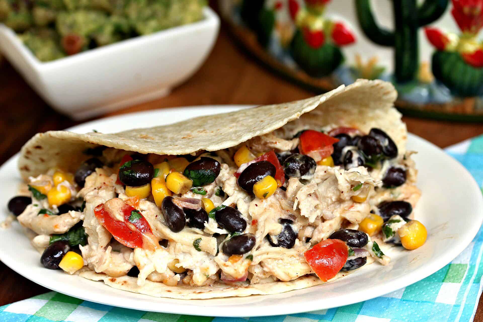 These crock pot chicken tacos are loaded with creamy shredded chicken and your favorite taco fillings. A perfect blend of flavors! CrockPot-Shredded-Chicken-Tacos