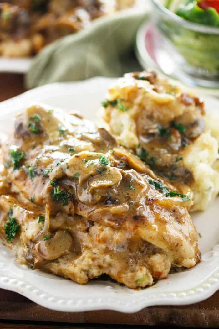 Make a classic Olive Garden meal from the comfort of your home with this ultra flavorful Stuffed Chicken Marsala recipe straight from the restaurant itself! close up view of stuffed chicken marsala topped with a marsala mushroom sauce and fresh parsley.