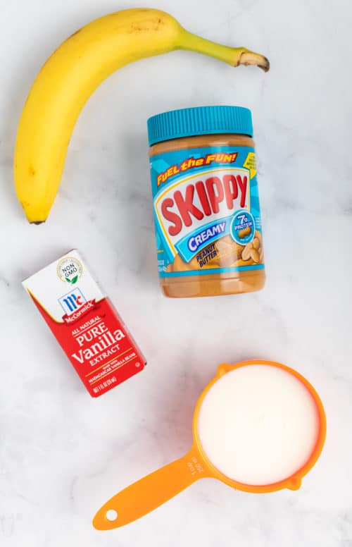 Overhead Shot of peanut butter, banana, milk, and vanilla extract for peanut butter smoothies.