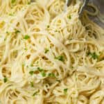 Garlic Parmesan Pasta in a skillet with kitchen tongs topped with parsley.