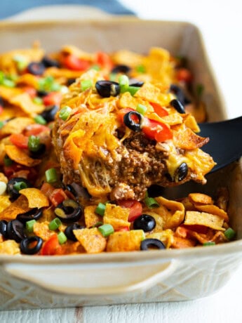 Taco casserole being scooped up from a casserole dish.