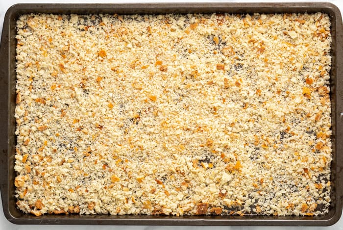 Learn how to make EASY homemade breadcrumbs! Store up to 3 months in the freezer and use for homemade meatballs, meatloaf, chicken, stuffing, casserole toppings, and more! #homemadebreadcrumbrecipe #easyrecipe #bread #breading #frying #panko Homemade breadcrumbs on a baking sheet.