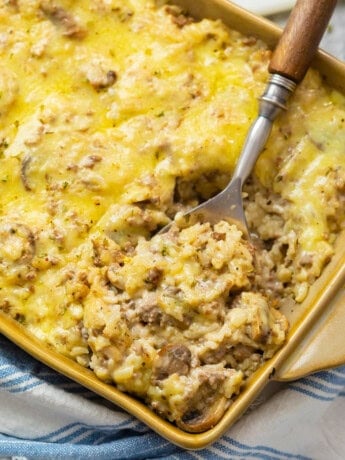 A casserole dish filled with cheesy ground beef and rice casserole.