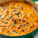 A green soup pot filled with creamy Chicken Enchilada Soup.