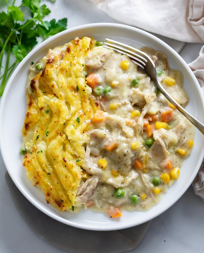 A white plate with Potatoes on the left and Chicken Shepherd's Pie on the right.