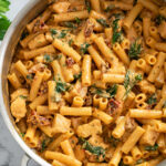 Marry Me Chicken in a skillet with a tomato cream sauce, sun-dried tomatoes, and spinach.