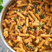 Marry Me Chicken in a skillet with a tomato cream sauce, sun-dried tomatoes, and spinach.