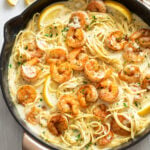 Lemon Shrimp Pasta in a skillet with a creamy lemon sauce topped with fresh parsley and slices of fresh lemon.